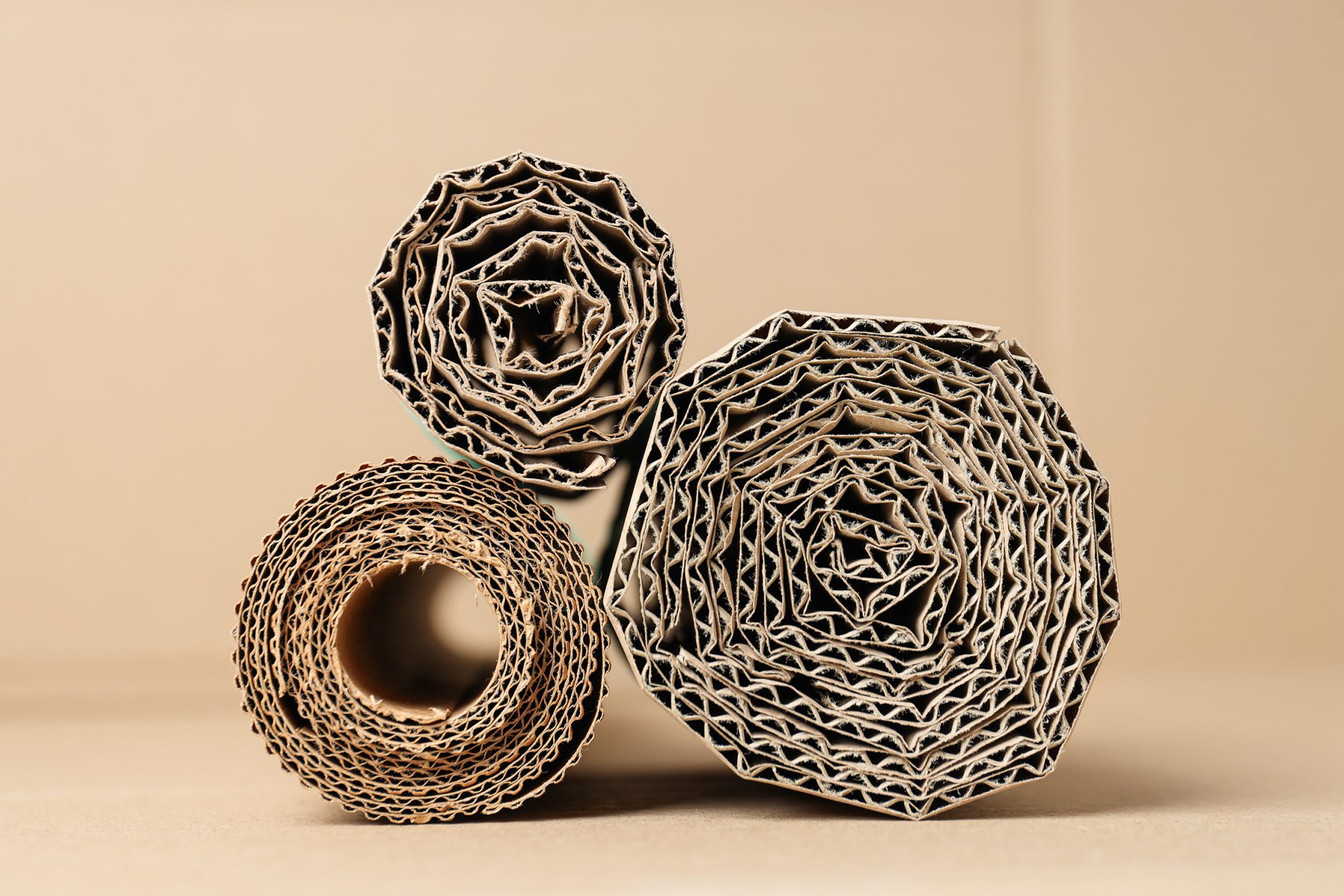 Corrugated cardboard is laid out in rolls on the table.